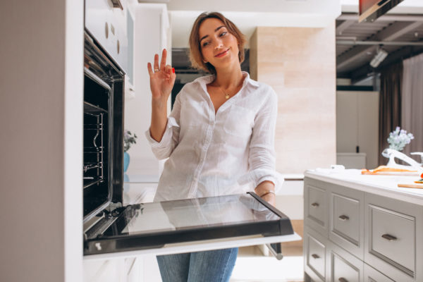 mujer horneando cocina mirando al horno scaled